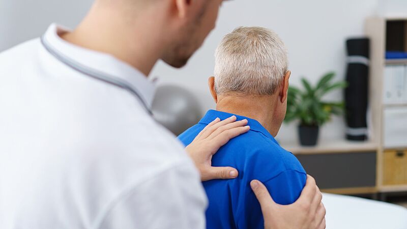 Arzt untersucht die Schulter eines Patienten Arzt untersucht die Schulter eines Patienten